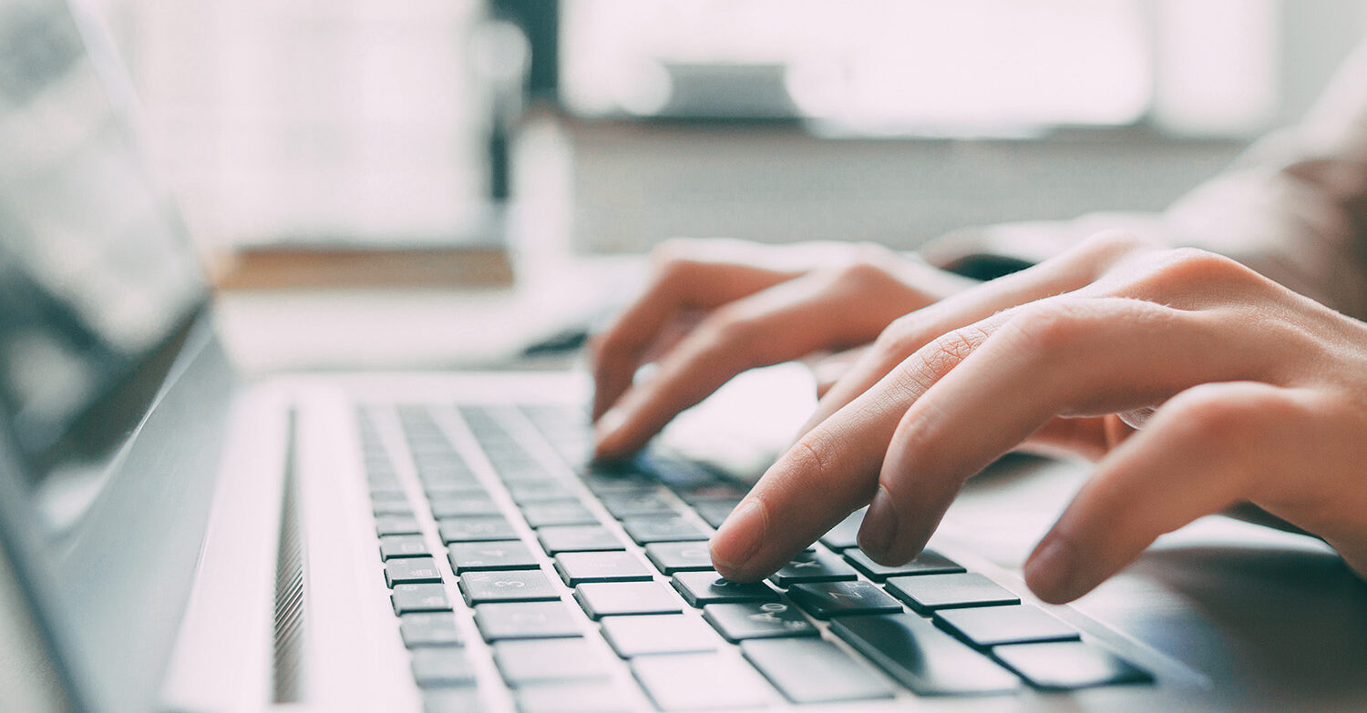 Hemsida i Wordpress - Två händer trycker på knapparna på ett tangentbord